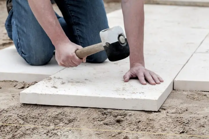 Installation of paving slabs with a huge hammer