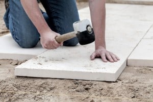 Man putting down pavers to be used for shed foundation