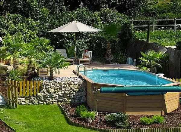 Modern oval above ground pools with decks and outdoor furniture umbrella
