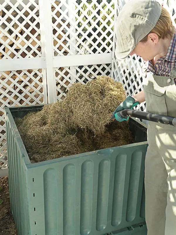 female farmer stiring mulch to help it decompose